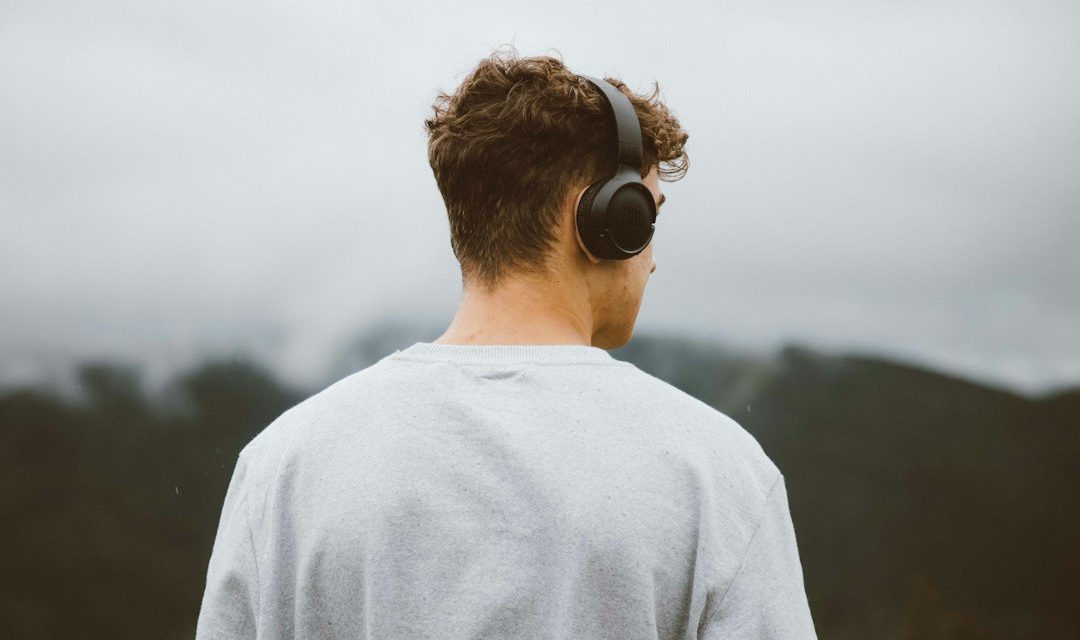 Pendengar memakai headphone sambil menikmati musik