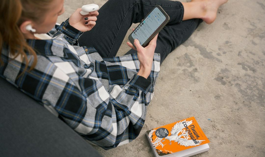 Seseorang membaca buku dan menggunakan tablet sebagai ilustrasi audiobook