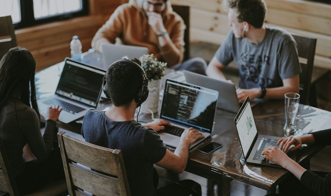 Sekelompok orang berkolaborasi menggunakan laptop
